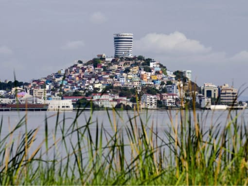 Vista del Cerro Santa Ana y sus coloridos edificios en Guayaquil bajo un cielo parcialmente nublado.